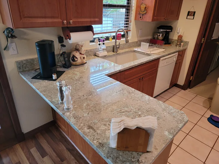 Cambria Kelvin Grove peninsula and undermount sink with warm wood cabinets