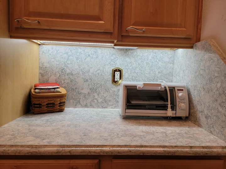 Cambria Montgomery full-height backsplash and countertop beneath wood cabinets