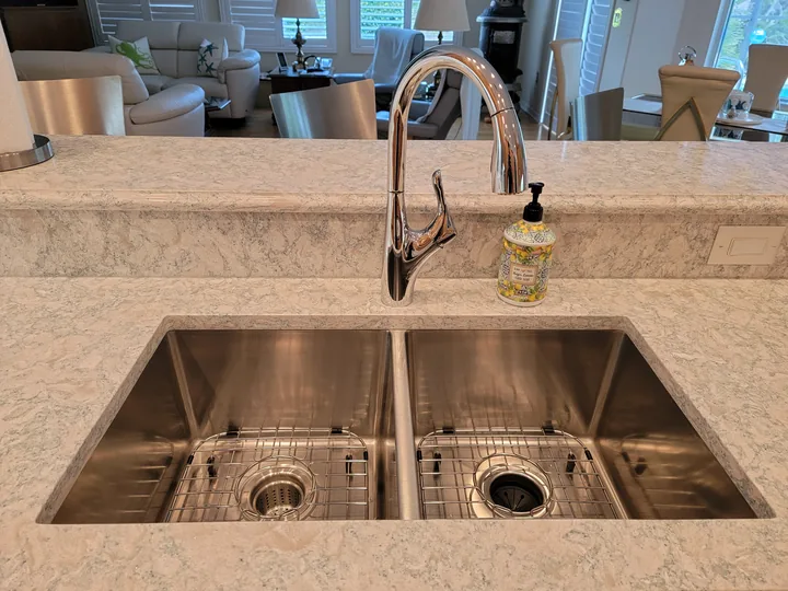 Double-bowl kitchen sink installed below a Cambria Montgomery raised bar