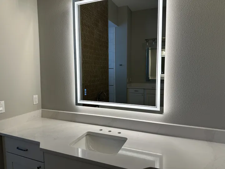 Bathroom vanity countertop with undermount sink and illuminated mirror