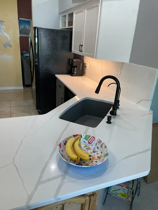 White quartz countertop with black undermount sink and faucet