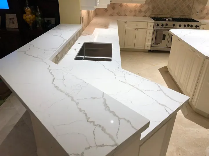 White quartz kitchen peninsula with integrated sink and raised bar