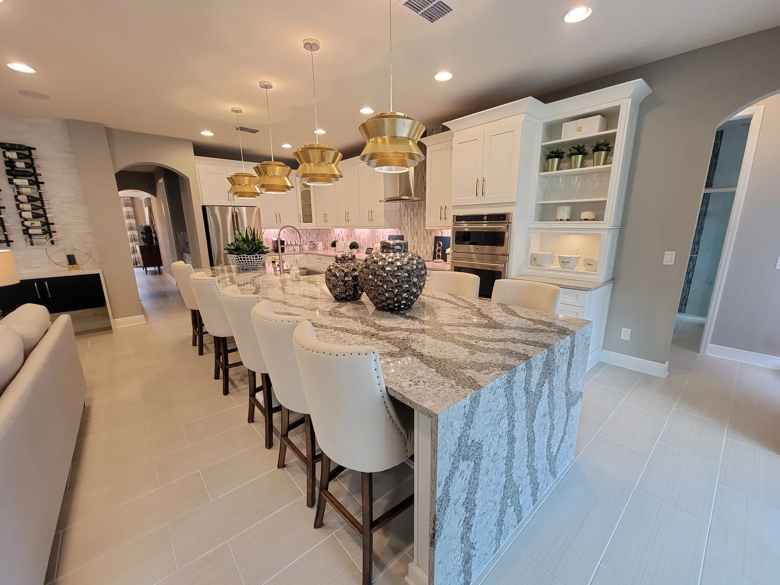Completed white kitchen with a dramatic waterfall stone island