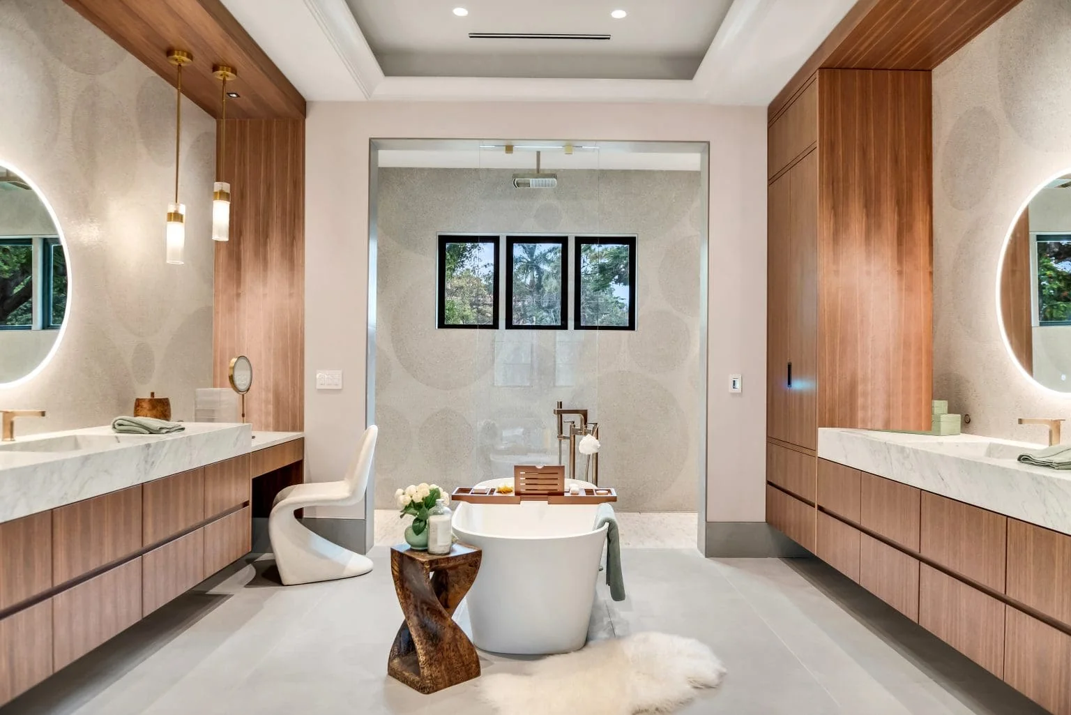 Primary bathroom with two stone vanities and freestanding tub