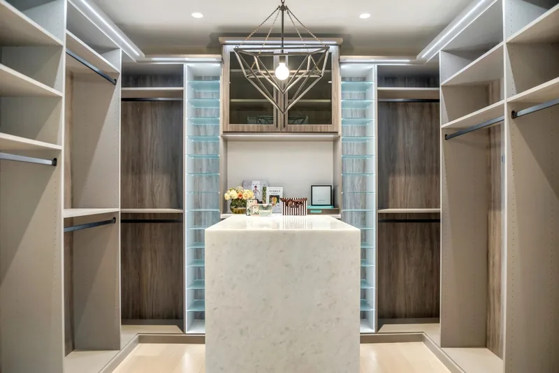 Primary closet with white stone waterfall island